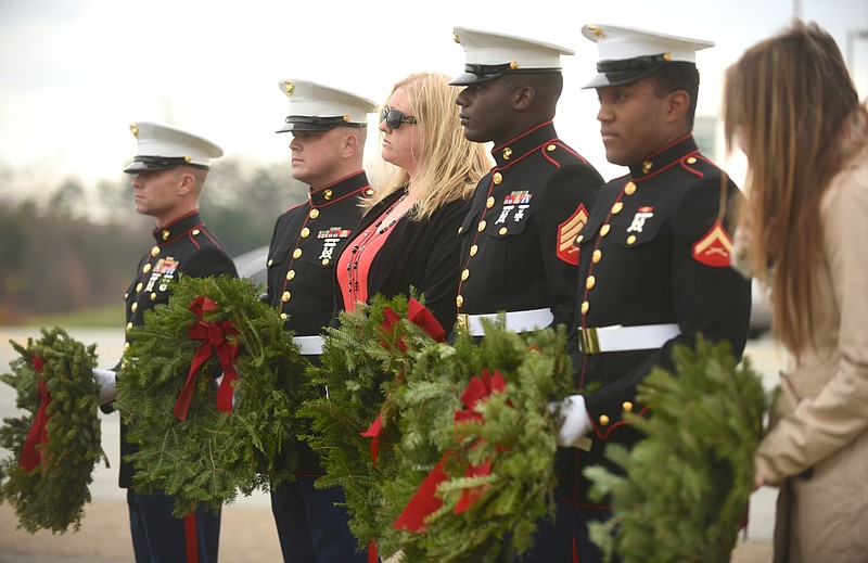 Marines Gunnery Sgt. William Potting, Staff Sgt. Christopher Estep, Sgt. Demonte Chieeley and Lance Cpl. Bryton Taylor, from left, stand with Lorri Wyatt, third from left, widow of Staff Sgt. David Allen Wyatt, and Angie Smith, right, widow of Navy Petty Officer 2nd Class Randall Smith, Wednesday, December 9, 2015, before placing wreaths at the Lee Highway memorial to five servicemen killed in July.