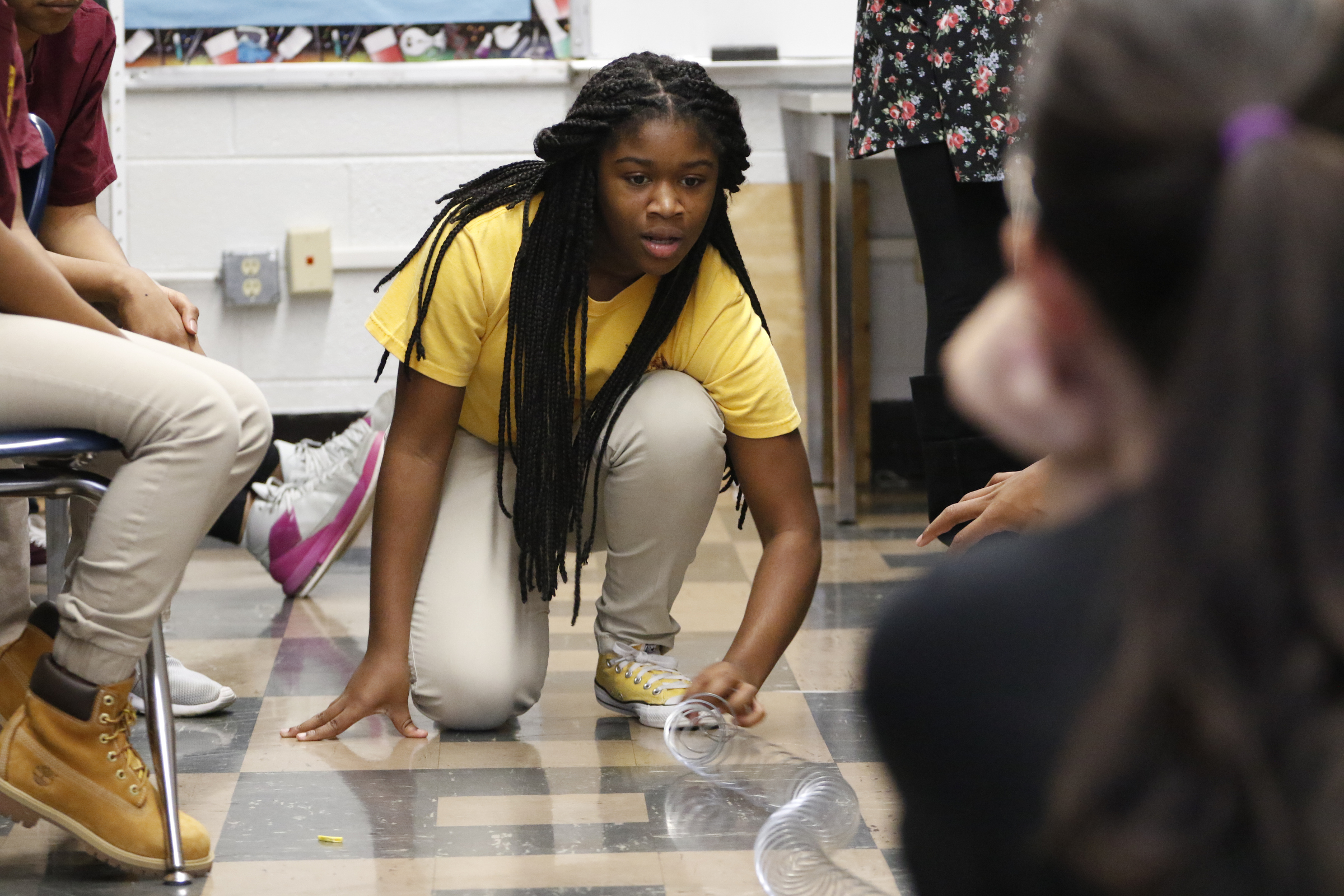Staff Photo by Dan Henry / The Chattanooga Times Free Press- 12/9/15. Sanai Dalton, left, and resident teacher Tiffany Cockran, right, use a slinky to visualize how a frequency works during Anthony Goad's 7th grade science class at Tyner Academy Middle School on Wednesday, December 9, 2015.
