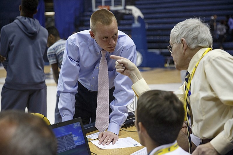 Jacob Kurtz, center, video coordinator for UTC men's basketball, talks to officials before the Mocs' game against Tennessee Wesleyan on Tuesday at McKenzie Arena. Kurtz came to Chattanooga with Mocs coach Matt McCall after the two were both part of University of Florida basketball under coach Billy Donovan.