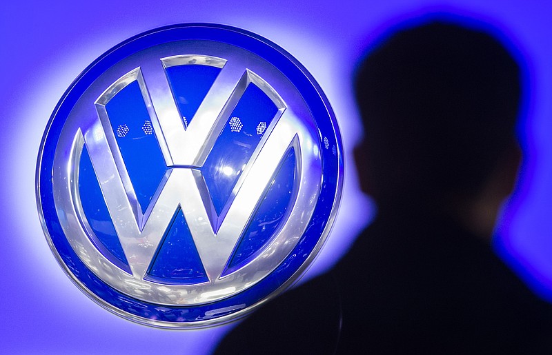 
              FILE - In this Sept. 23, 2015 file photo the silhouette of visitor pictured next to the logo of German car manufacturer Volkswagen AG at the International Motor Show IAA in Frankfurt, Germany. Volkswagen said Wednesday, Dec. 9, 2015, that a problem with carbon dioxide emissions is far smaller than initially suspected, with further checks finding "slight discrepancies" in only a few models and no evidence of illegal changes to fuel consumption and emissions figures. (Boris Roessler/dpa via AP, File)
            