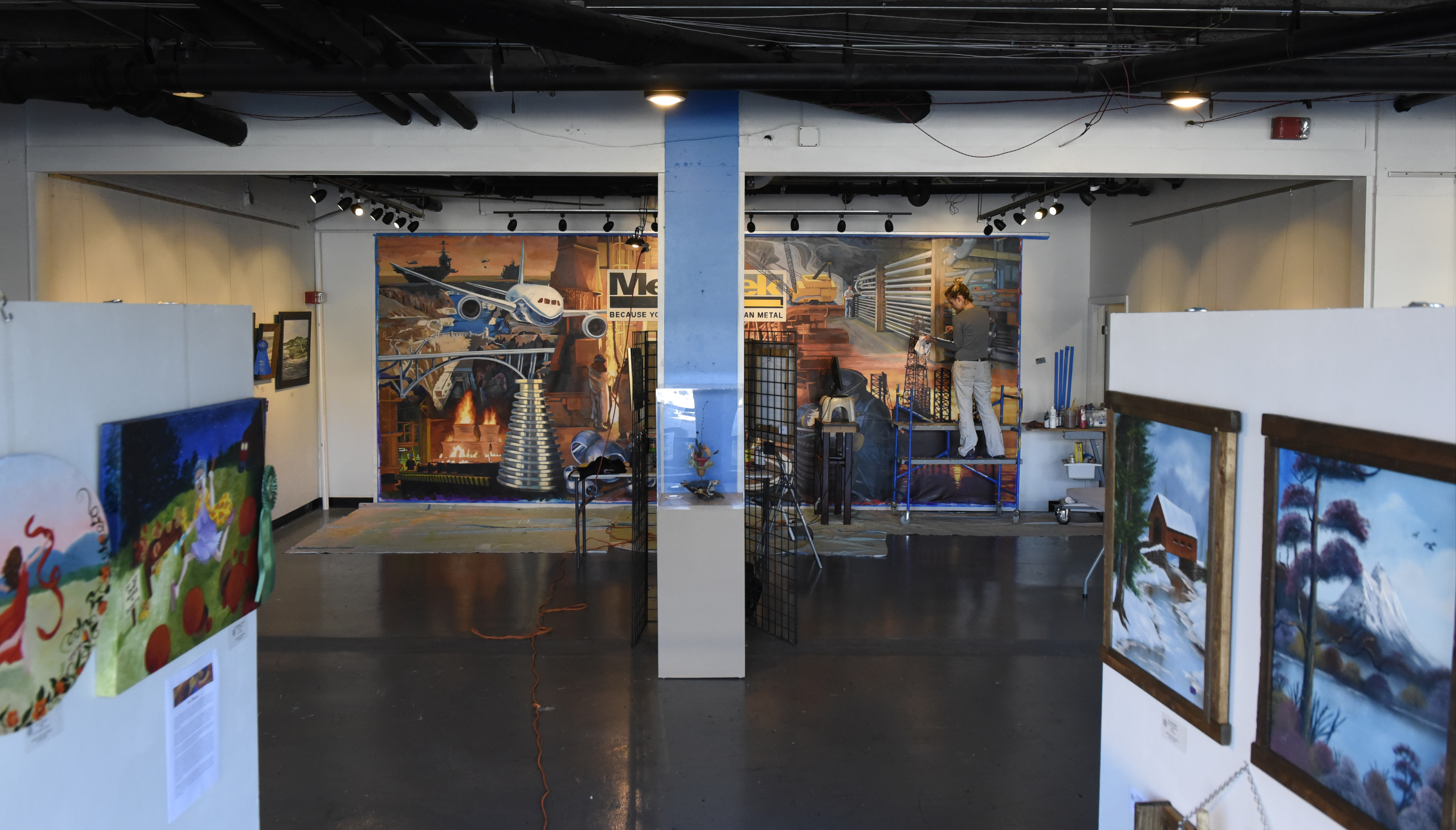 Ali Kay works on a mural in the lobby of the Chattanooga WorkSpace building on Thursday, Nov. 19, 2015, in Chattanooga, Tenn. This mural, eight feet tall and 21 feet wide, is one of eight of her murals that will be displayed in offices of MetalTek around the country.