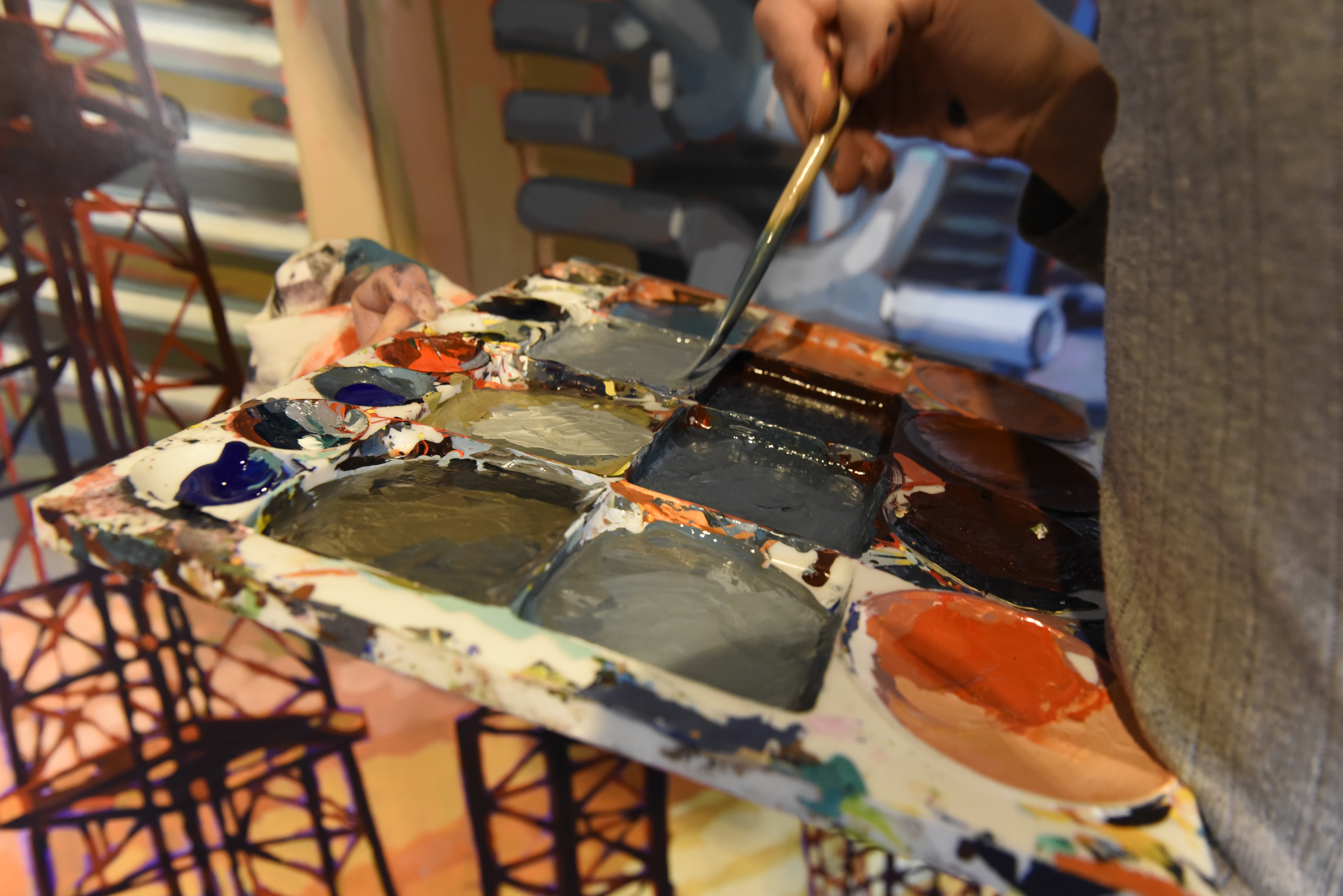 Ali Kay gets paint on her brush as she works on a mural in the lobby of the Chattanooga WorkSpace building on Thursday, Nov. 19, 2015, in Chattanooga, Tenn. This mural, eight feet tall and 21 feet wide, is one of eight of her murals that will be displayed in offices of MetalTek around the country.