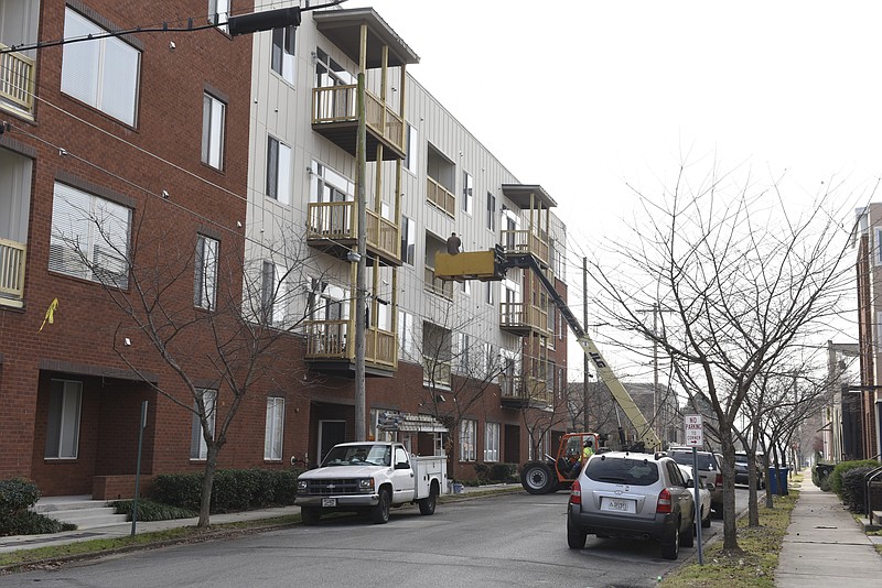Workers use a lift to access a third floor residential unit on Long Street in the Southside area on Thursday, Dec. 10, 2015, in Chattanooga, Tenn. 