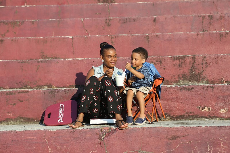 The state of the stands at Tyner High School is evident as Brandi Oeum and her son, Braylon McCallie, share refreshments at a Tyner-Notre Dame football game in August.