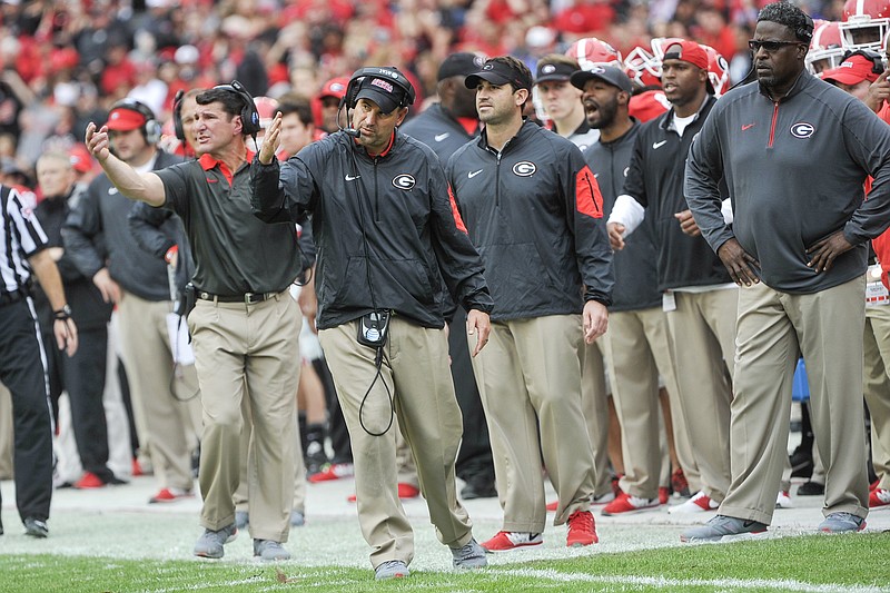 Georgia assistant coaches including linebackers coach Mike Ekeler, left, defensive coordinator Jeremy Pruitt, second from left, strength and conditioning coach Mark Hocke, third from left, and Tracy Rocker, right, work the sideline during the second half of an NCAA college football game against Kentucky, Saturday, Nov. 7, 2015, in Athens, Ga. Georgia won 27-3. (AP Photo/John Amis)
