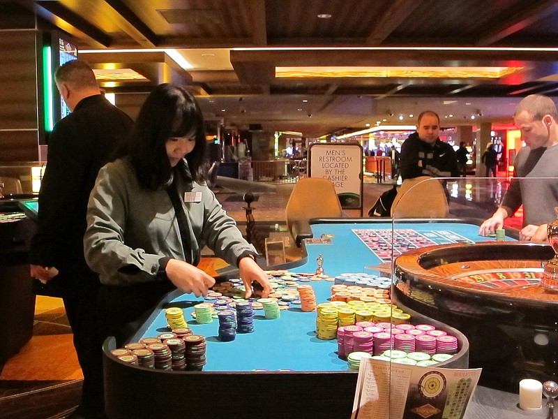 This photo shows a dealer counting chips during a game of roulette at a casino.