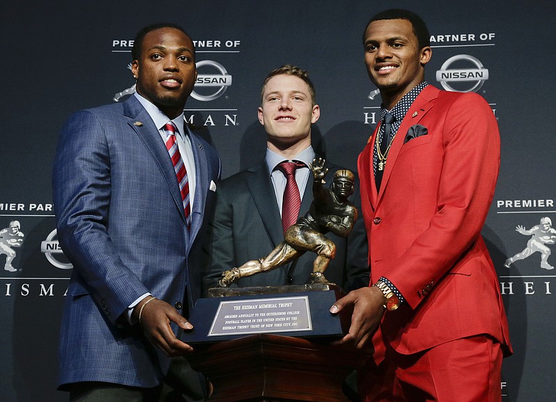 
              Heisman Trophy finalists, from left, Alabama's Derrick Henry, Stanford's Christian McCaffrey and Clemson's Deshaun Watson pose for a photo with the Heisman Trophy before the start of the award presentation show, Saturday, Dec. 12, 2015, in New York. (AP Photo/Julie Jacobson)
            