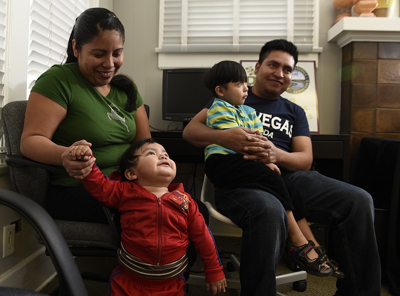 Alicia Andres, left, is photographed Wednesday, Dec. 2, 2015, in Chattanooga, Tenn., with two of her five sons, 10-month-old Jesus Antonio, Jr., left, and Pablo Antonio, sitting in the lap of her husband, Jesus Antonio. Andres received $300 from the Neediest Cases fund to help pay rent after her husband was treated for a brain tumor.