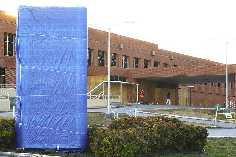 Workers wrap the signage and board up the former Emergency Room entrance at Hutcheson Medical Center in Fort Oglethorpe, Ga.