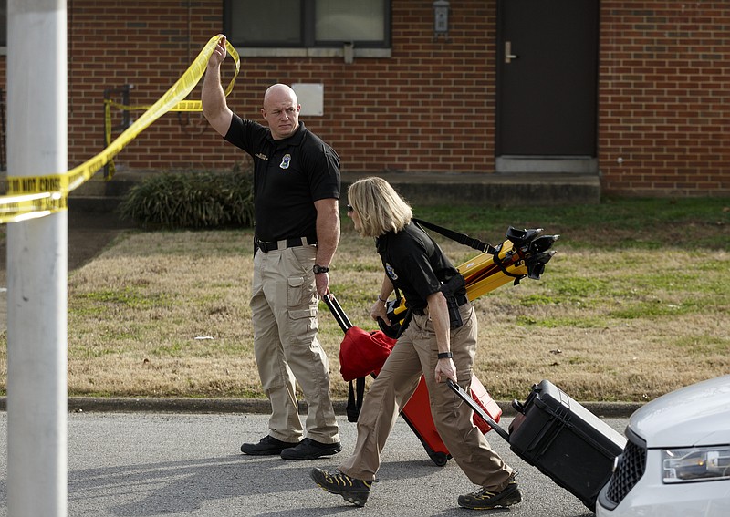 Chattanooga Police crime scene investigators carry 3D imaging equipment to the scene of a Chattanooga police officer-involved shooting at Emma Wheeler Homes on Saturday.