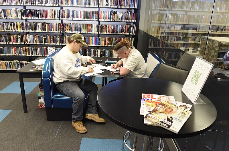 John and Jessica Moore sit in a booth in the new teen section at the Dalton-Whitfield County Public Library on Monday, Dec. 14, 2015, in Dalton, Ga. The library reopened on Monday after being closed for remodeling and renovations. 