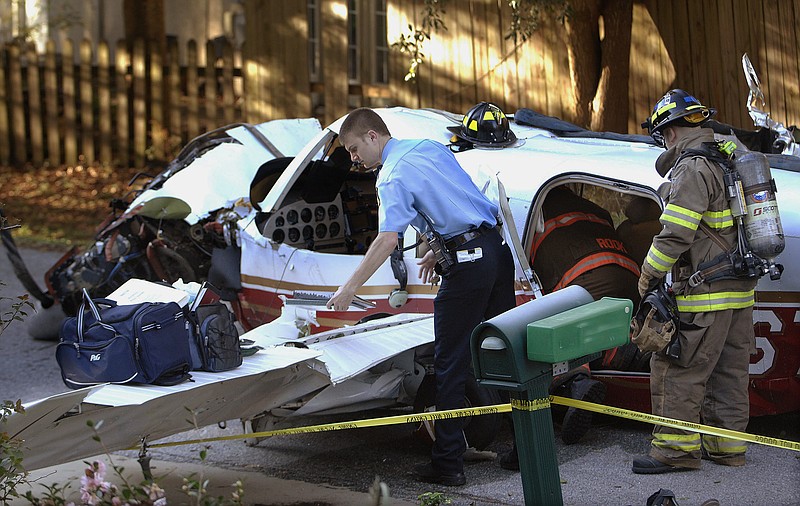 
              Glynn County firefighters remove the personal belongings of two men who were aboard the plane that crashed onto the roof of a home in St. Simons Island, Ga., after reporting engine trouble Tuesday, Dec. 15, 2015. The two people aboard suffered minor injuries and the two homeowners were at home but not injured. (Terry Dickson/The Florida Times-Union via AP) MANDATORY CREDIT
            