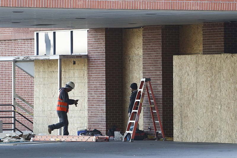 Workers finish boarding up the former emergency room entrance at Hutcheson Medical Center earlier this month.