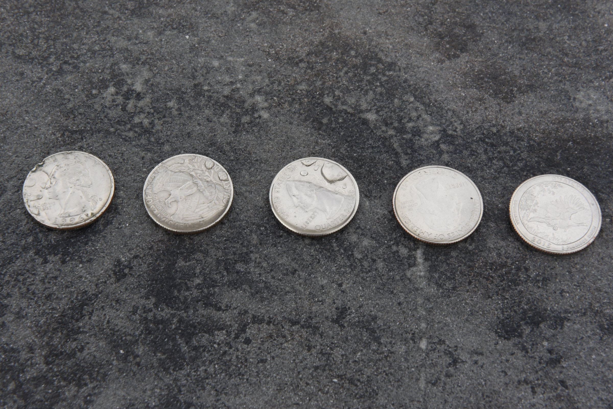 Five quarters are seen atop the memorial to the five service members killed in a terror incident on July 16, 2015, is photographed on Monday, Dec. 14, 2015, in Chattanooga, Tenn. The memorial is located in front of the Armed Forces Career Center on Lee Highway next to Highway 153, the scene of the first shots fired in the July attack.