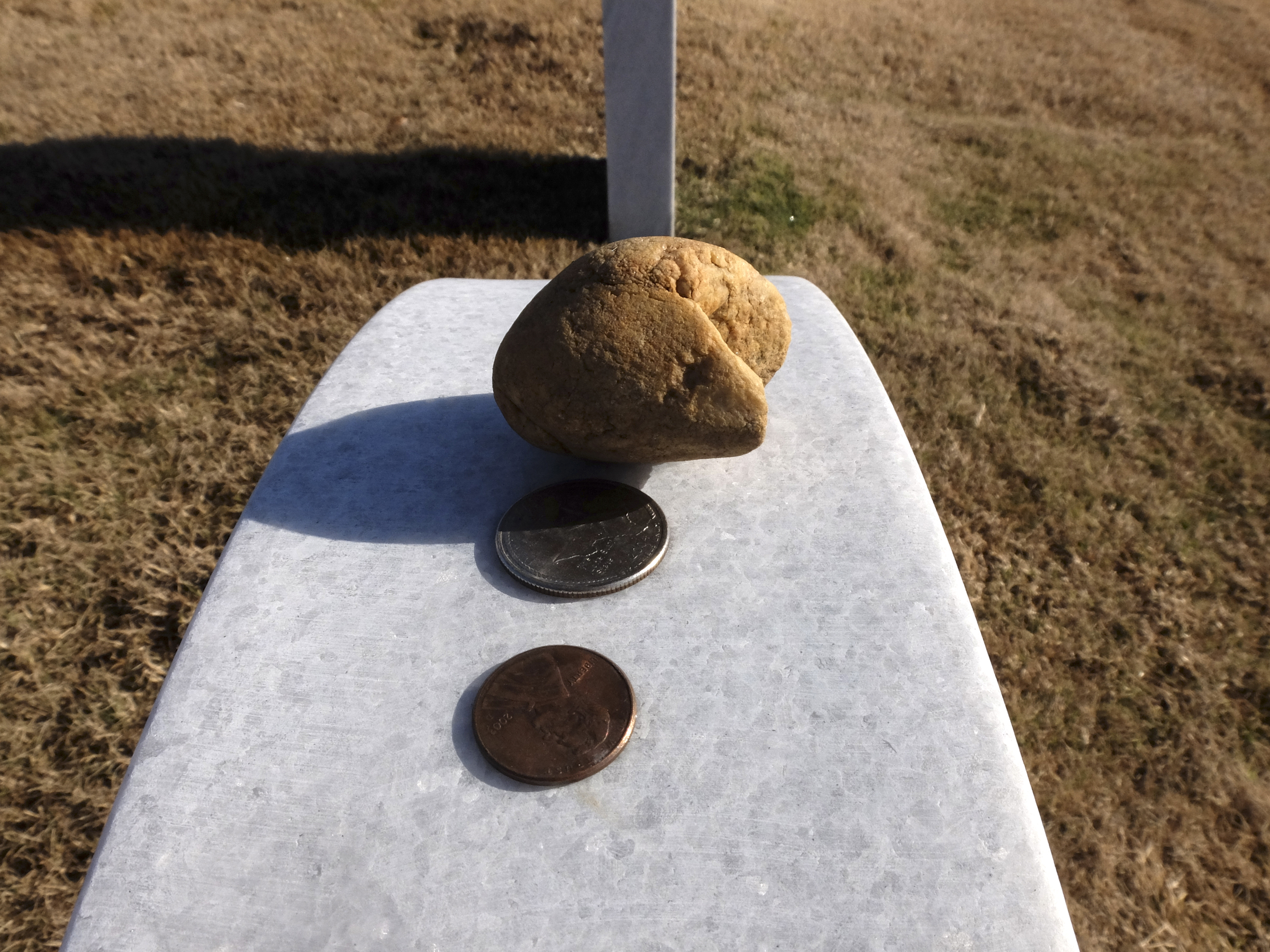 A creek stone, a quarter-dollar and a penny rests atop the head stones of U.S. Navy LS2 Randall Scott Smith, and Marine SSgt David A. Wyatt at the Chattanooga National Cemetery.