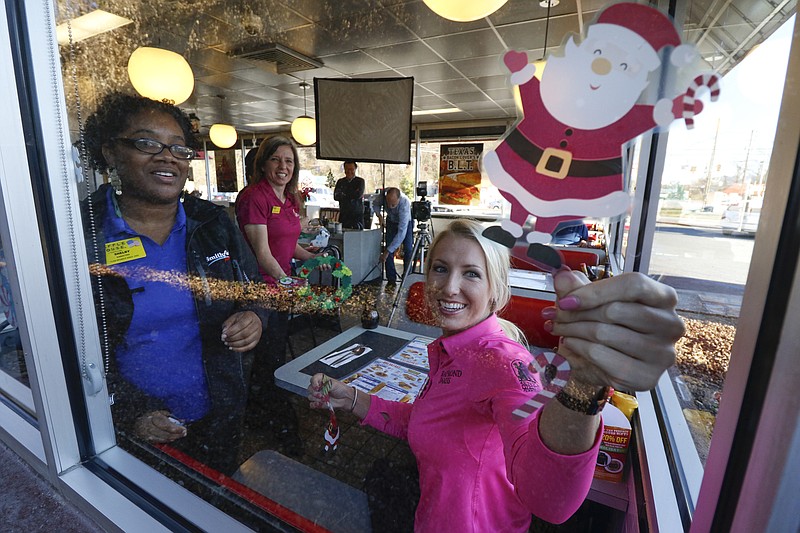 Staff Photo by Dan Henry / The Chattanooga Times Free Press- 12/16/15. Baylor School golfer Brooke Pancake, who now plays on the professional women's golf tour and has signed an endorsement deal with Waffle House, removes holiday themed stickers before partaking in a promotional photo shoot at the Red Bank restaurant on Wednesday, December 16, 2015. 