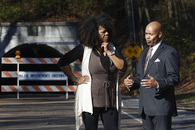 Staff Photo by Dan Henry / The Chattanooga Times Free Press- 12/16/15. Business owners Tia Taylor-Clark with Jane of Trades Upscale Resale, left, and Taylor Funeral Home director John Taylor, right, discuss how the closure of the Wilcox Tunnel has negatively affected their businesses while standing in front of the closed thoroughfare on Wednesday, December 16, 2015. 
