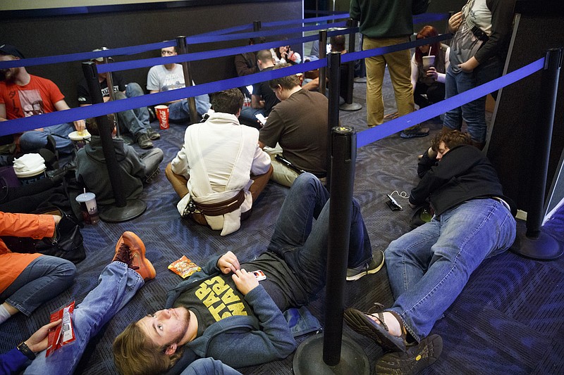 Gavin Tierce, lower left, waits in line with other fans at the premiere of Star Wars: The Force Awakens at Carmike East Ridge 18 theaters on Thursday, Dec. 17, 2015, in Chattanooga, Tenn. Theaters had showtimes as early as 7 p.m. for one of the biggest opening nights in movie history.