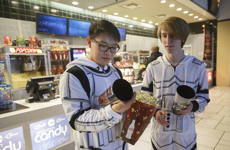 Joseph Chu, left, and Austin Roach look at collectable cups they bought at the premiere of Star Wars: The Force Awakens at Carmike East Ridge 18 theaters on Thursday, Dec. 17, 2015, in Chattanooga, Tenn. Theaters had showtimes as early as 7 p.m. for one of the biggest opening nights in movie history.