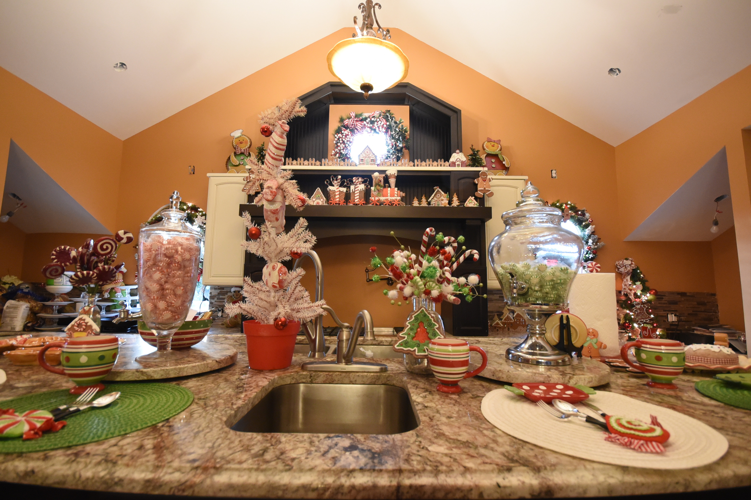The kitchen is a candyland of peppermints and gingerbread. A gingerbread train and village decorates shelves above the stove on the rear wall. Glass beverage dispensers hold peppermints until they are filled with liquids for parties. Place settings include lollipop silverware holders and candy-striped cups. Ceramic gingerbread cookie jars fill four built-in shelves between the kitchen's two refrigerator-freezers. The Myers designed their kitchen to accommodate the entertaining they do. In addition to the two refrigerators, it has four dishwashers, six sinks, four ovens and two islands with built-in warming and cooling drawers.
