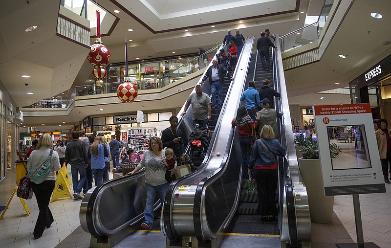 Shoppers take an escalator at Hamilton Place Mall on Friday, Dec. 18, 2015, in Chattanooga, Tenn. This weekend is one of the busiest shopping weekends of the year.