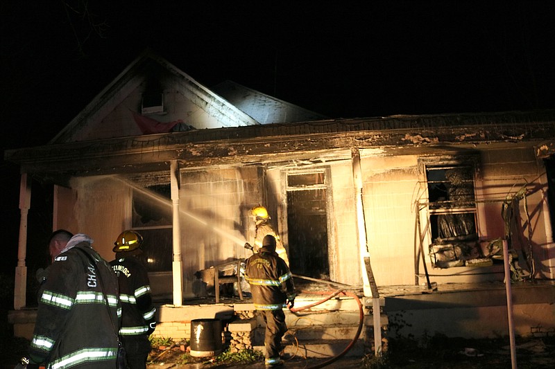 Firefighters finish putting out hot spots at this morning's fire on 14th Avenue. Photo by Bruce Garner.