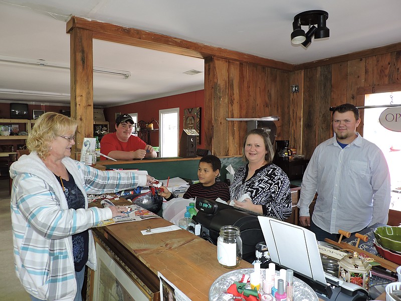 Red Barn Variety & Consignment is selling lots of Christmas ornaments. From left Lynn Schlageter, of LaFayette, buys Christmas ornaments, while Travius Shackleford, 9, and co-owners Christina Dodd and Levi Dodd assist in the sale, from left. Travius and Levi are Christina Dodd's sons who help out at the LaFayette store.