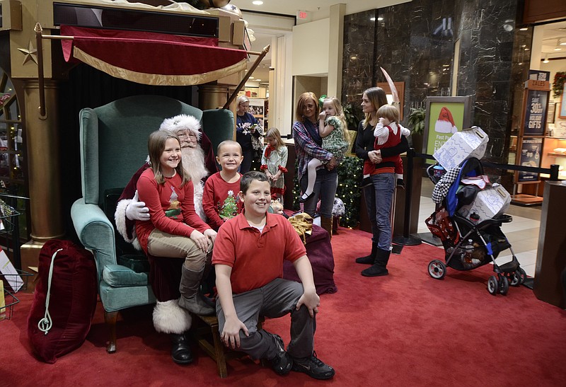 Left to right: Haven, Christopher and Austin Winship take their photo with Santa while doing their Christmas shopping at Hamilton Place Mall in Chattanooga, Tenn., on Thursday, December 18, 2014.