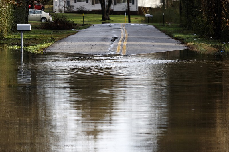 Longview Drive is made impassible by floodwater after heavy rains brought flooding to the region Saturday, Dec. 26, 2015, in Hixson, Tenn. Rain is expected to continue into the next week.