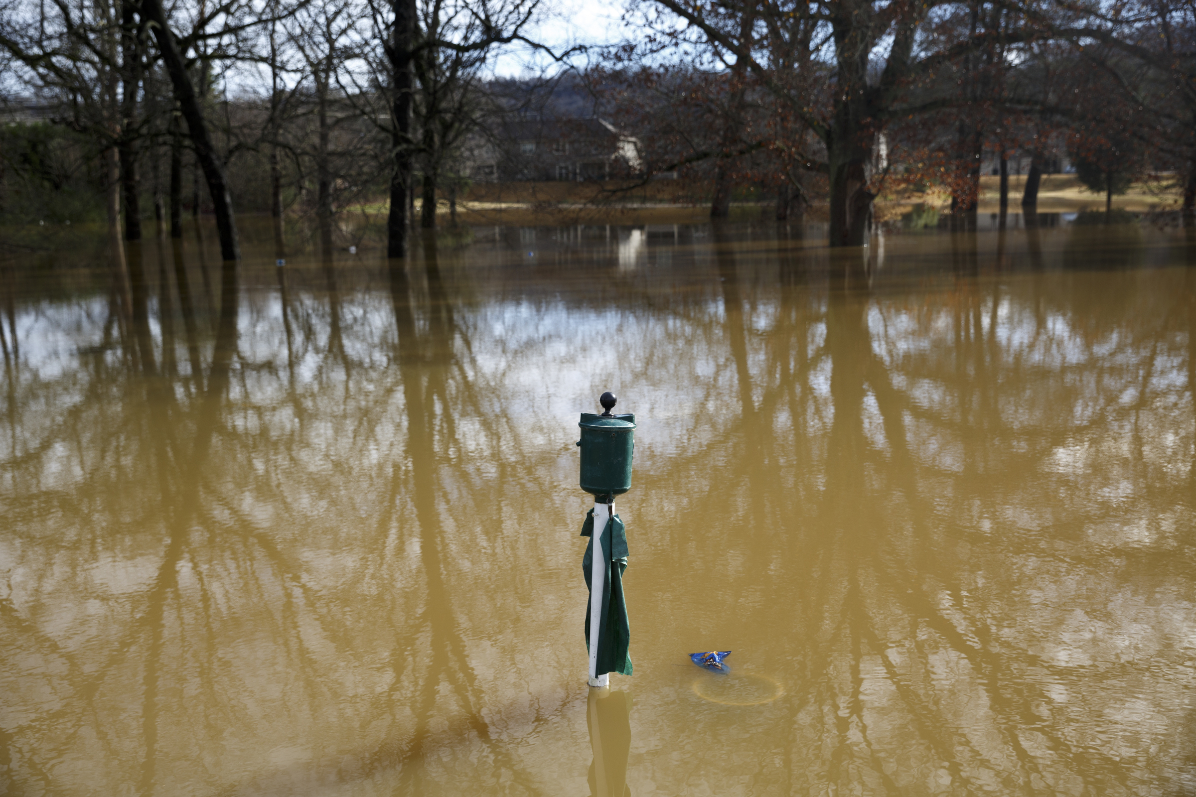 A ball-cleaner is visible through floodwaters covering Creek's Bend Golf Course after heavy rains brought flooding to the region Saturday, Dec. 26, 2015, in Hixson, Tenn. Rain is expected to continue into the next week.