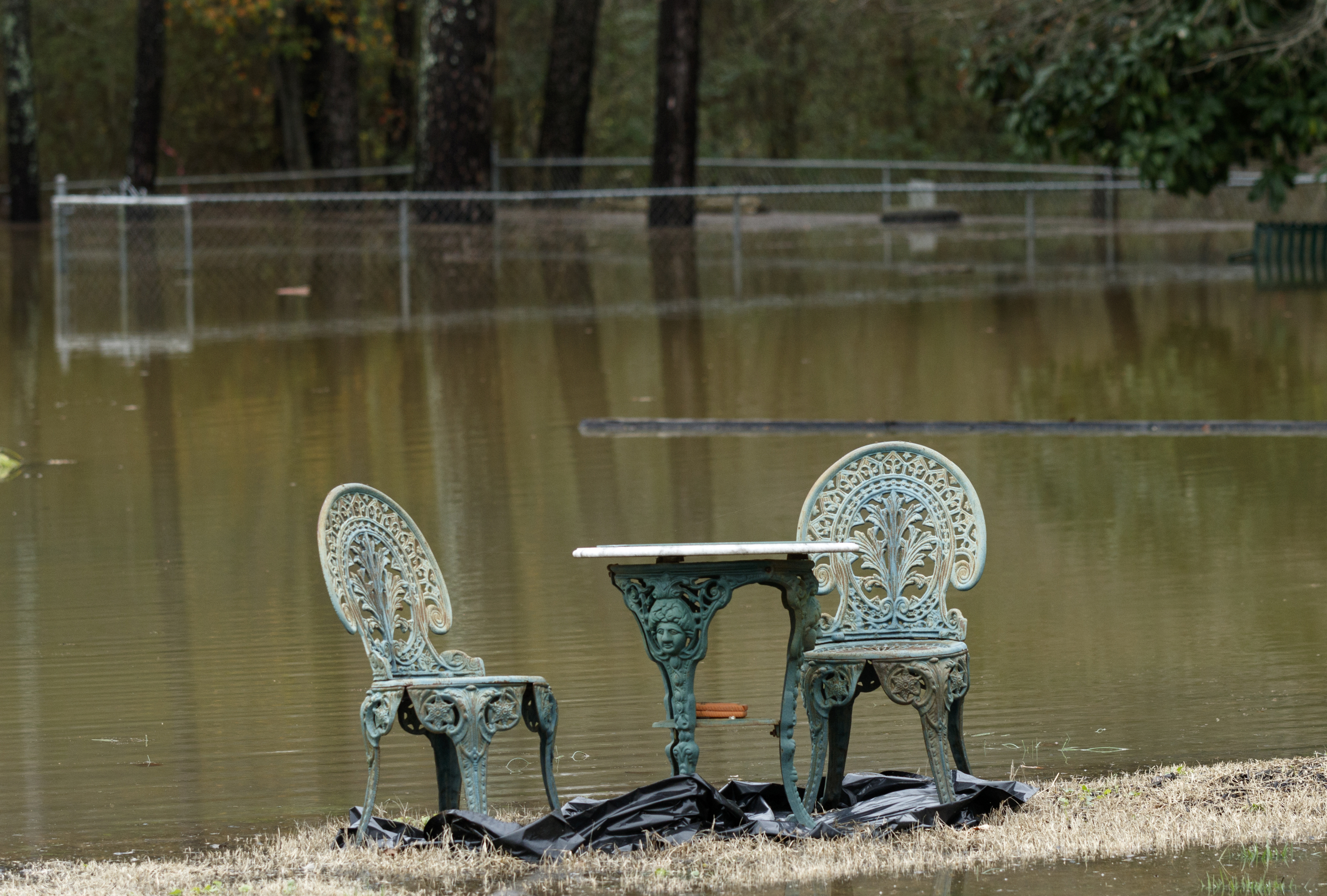 An outdoor set sits just clear of rising floodwater on Spring Valley Drive after heavy rains brought flooding to the region Saturday, Dec. 26, 2015, in East Ridge, Tenn. Rain is expected to continue into the next week.