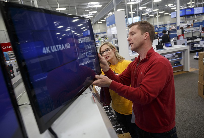 Stephen Lay, right, and Melody Lay look at a flatscreen television during post-Christmas shopping at Best Buy on Saturday, Dec. 26, 2015, in Chattanooga, Tenn.