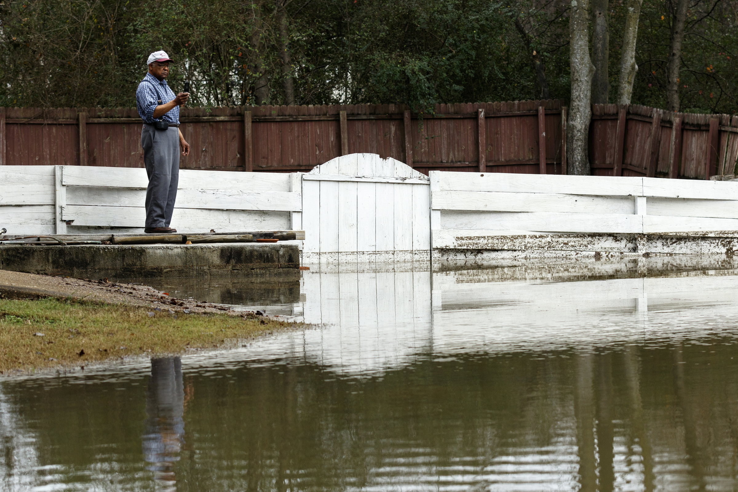 A man records video of flooding in his yard on Nottingham Drive after Christmas day rainfall brought South Chickamauga Creek to a flood stage of about 26.5 feet on Sunday, Dec. 27, 2015, in East Ridge, Tenn. Major flood stage classification for the creek is 27 feet.