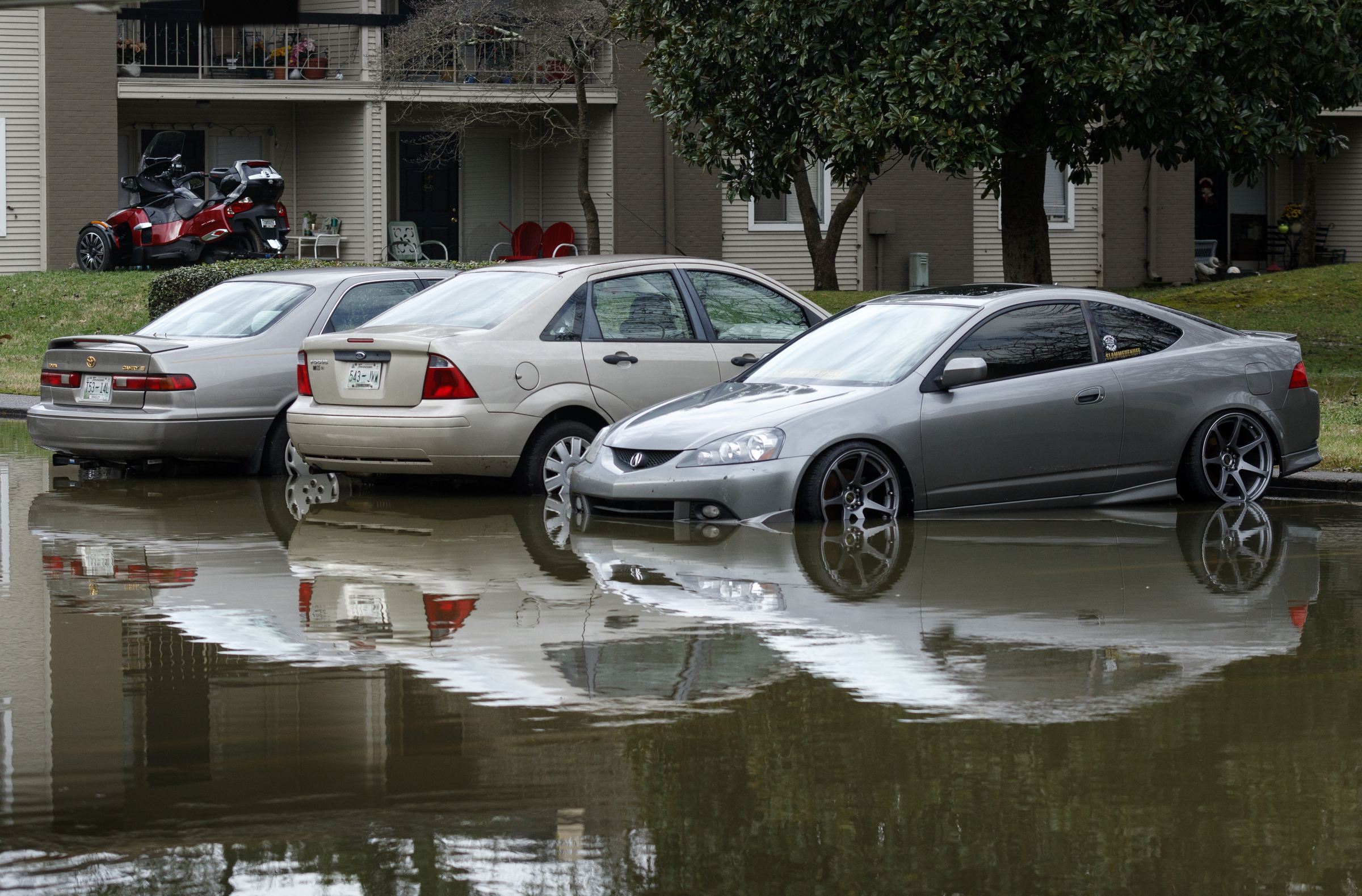 Cars are partly submerged in the Spring Creek Gardens apartments parking lot after Christmas day rainfall brought South Chickamauga Creek to a flood stage of about 26.5 feet on Sunday, Dec. 27, 2015, in East Ridge, Tenn. Major flood stage classification for the creek is 27 feet.