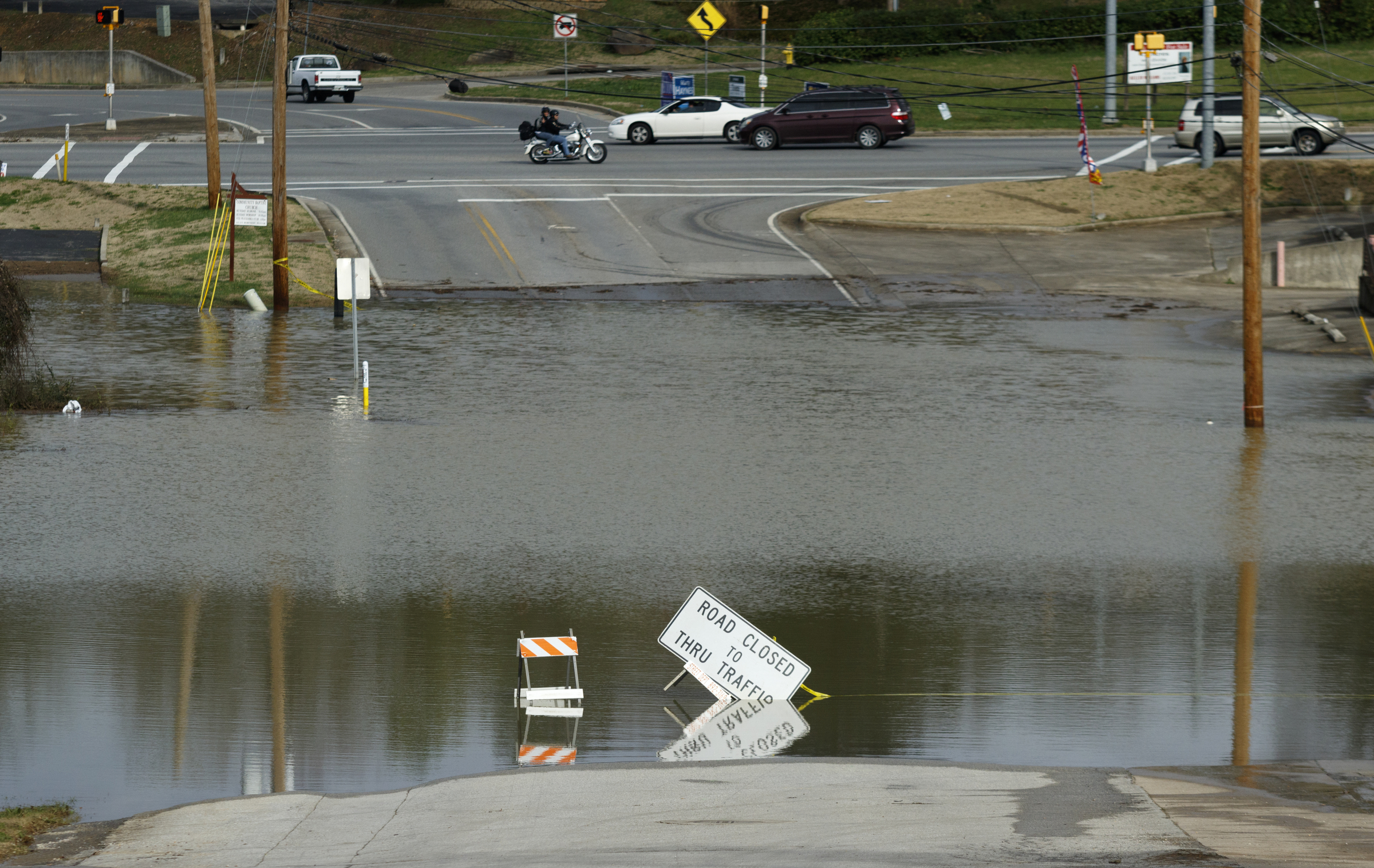 Scruggs Road is closed by flooding after Christmas day rainfall brought South Chickamauga Creek to a flood stage of about 26.5 feet on Sunday, Dec. 27, 2015, in East Ridge, Tenn. Major flood stage classification for the creek is 27 feet.