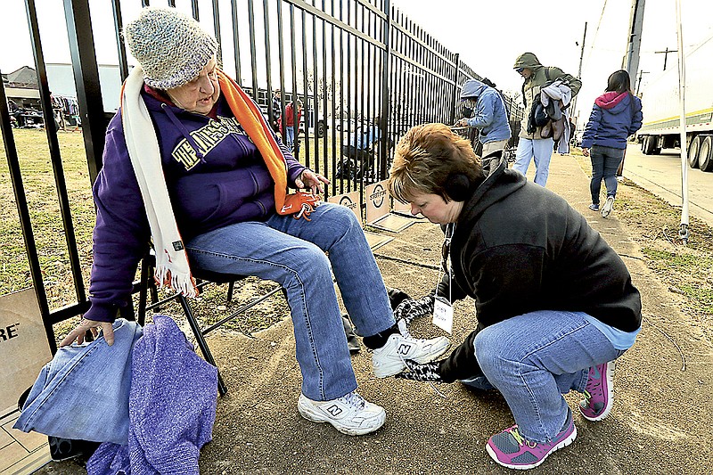 Wanda Rodewald, left, is aided by Tricia Foster in picking out a new pair of shoes during the "Street Store" event run by Southern Adventist University and Salvation Army volunteers offering free clothes and lunches for the homeless as a Martin Luther King Day service project on Monday, January 19, 2015.