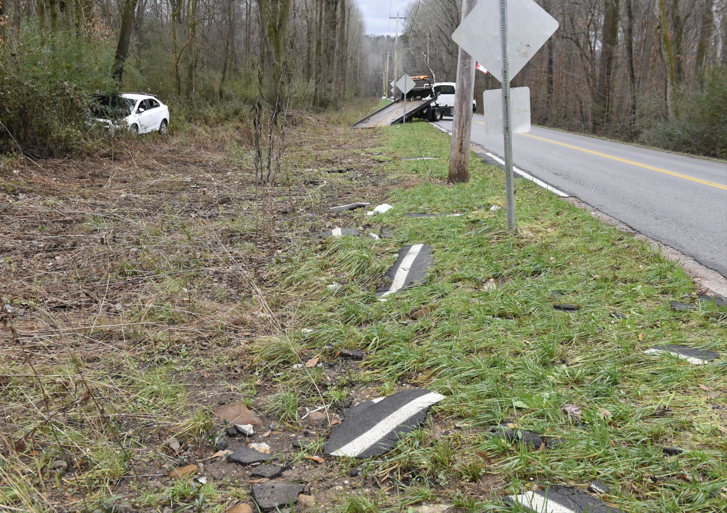 Sections of washed out pavement are seen in the foreground as a Conley Wrecker Service vehicle pulls in a Chevrolet on Monday, Dec. 28, 2015, near Chattanooga, Tenn., from the tree line beside of Boy Scout Road. The Chevrolet with Shelby County tags apparently washed off of the flooded road during heavy rain on Christmas day.