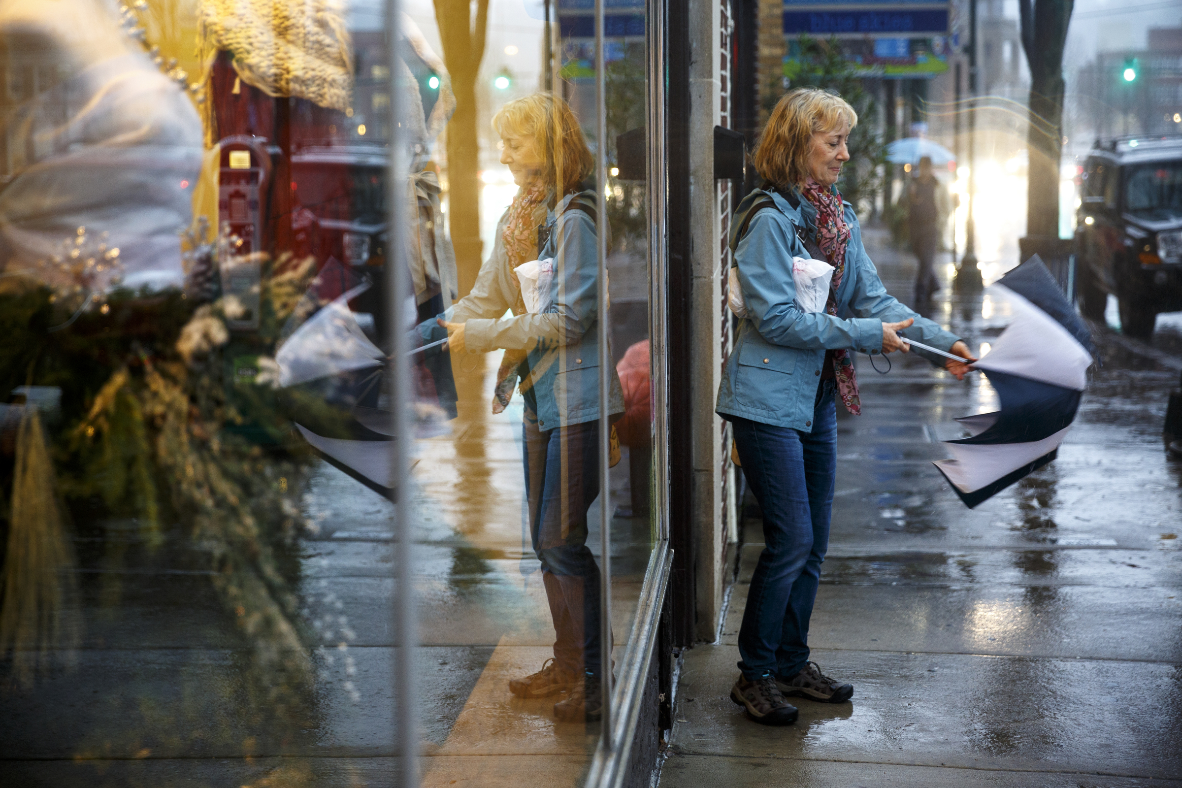 Cindy Ouzts puts away her umbrella to enter a shop on Frazier Avenue as rain falls after additional storms swept through the region Monday, Dec. 28, 2015, in Chattanooga, Tenn. The region recorded record-high temperatures over the past week amid heavy rainfall.