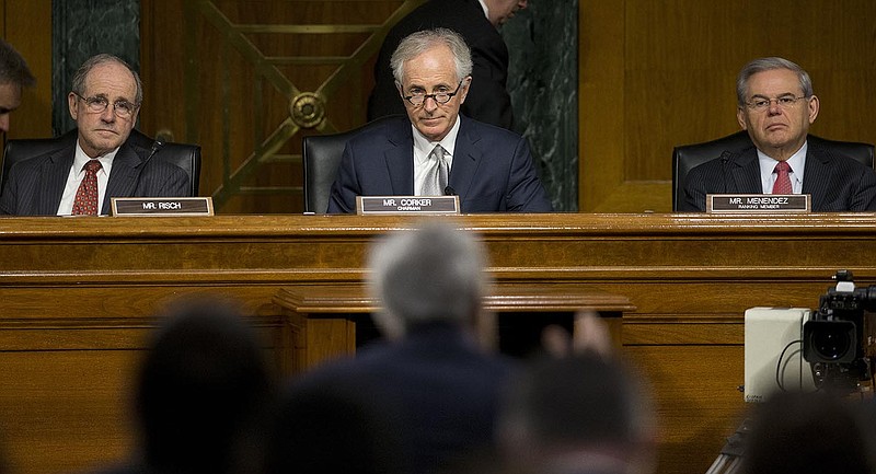 Senate Foreign Relations Committee, Chairman Sen. Bob Corker, R-Tenn., center, flanked by the committee's ranking member Sen. Robert Menendez, D-NJ., right, and Sen. James Risch, R-Idaho, listens on Capitol Hill in Washington, Wednesday, March 11, 2015, as Secretary of State John Kerry, center, back to camera, testifies. Three of America's top national security officials face questions on Capitol Hill about new war powers being drafted to fight Islamic State militants, Iran's sphere of influence and hotspots across the Mideast. (AP Photo/Pablo Martinez Monsivais)