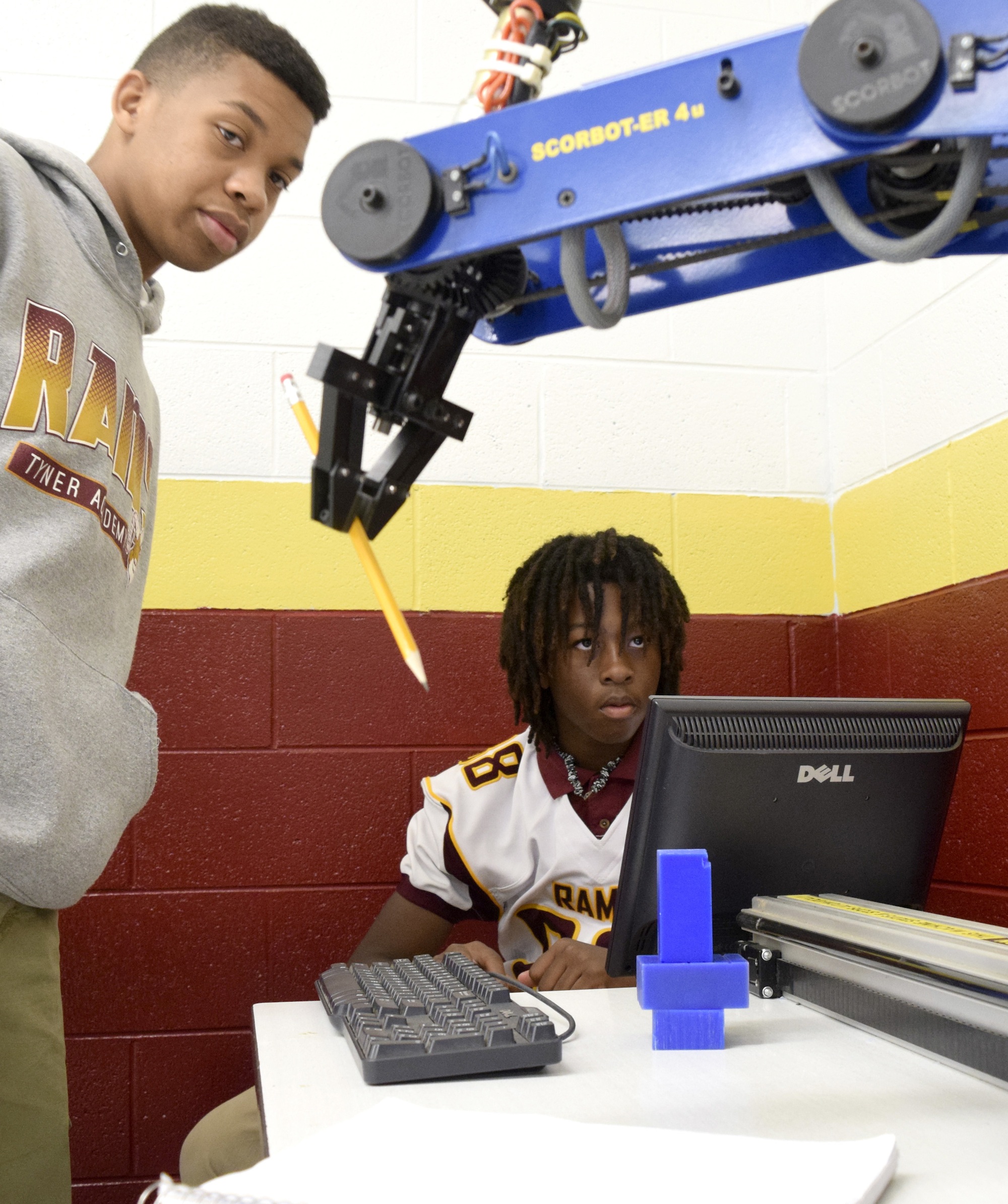 Tyner students Rickey Berry (left) and Jordon Torrance practice writing with a robot arm. Tyner High teacher Bryan Robinson has started a mechatronics program that offers student the opportunity to graduate with a specific certification that will aid them in finding jobs with high-tech companies.