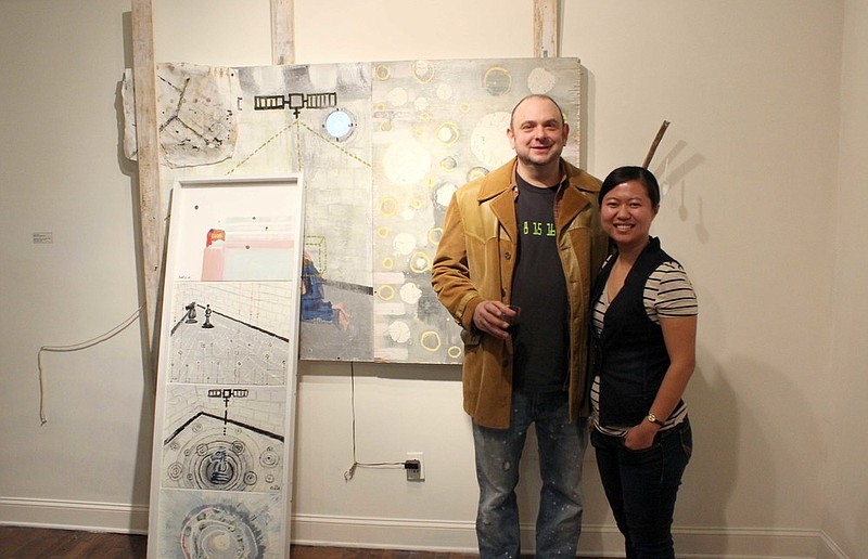 Juror Giang Pham, right, who teaches studio foundations at the University of Alabama in Tuscaloosa, selected "Behind Concrete Walls" as Best in Show, earning artist Brent Weston, left, a solo show next November.