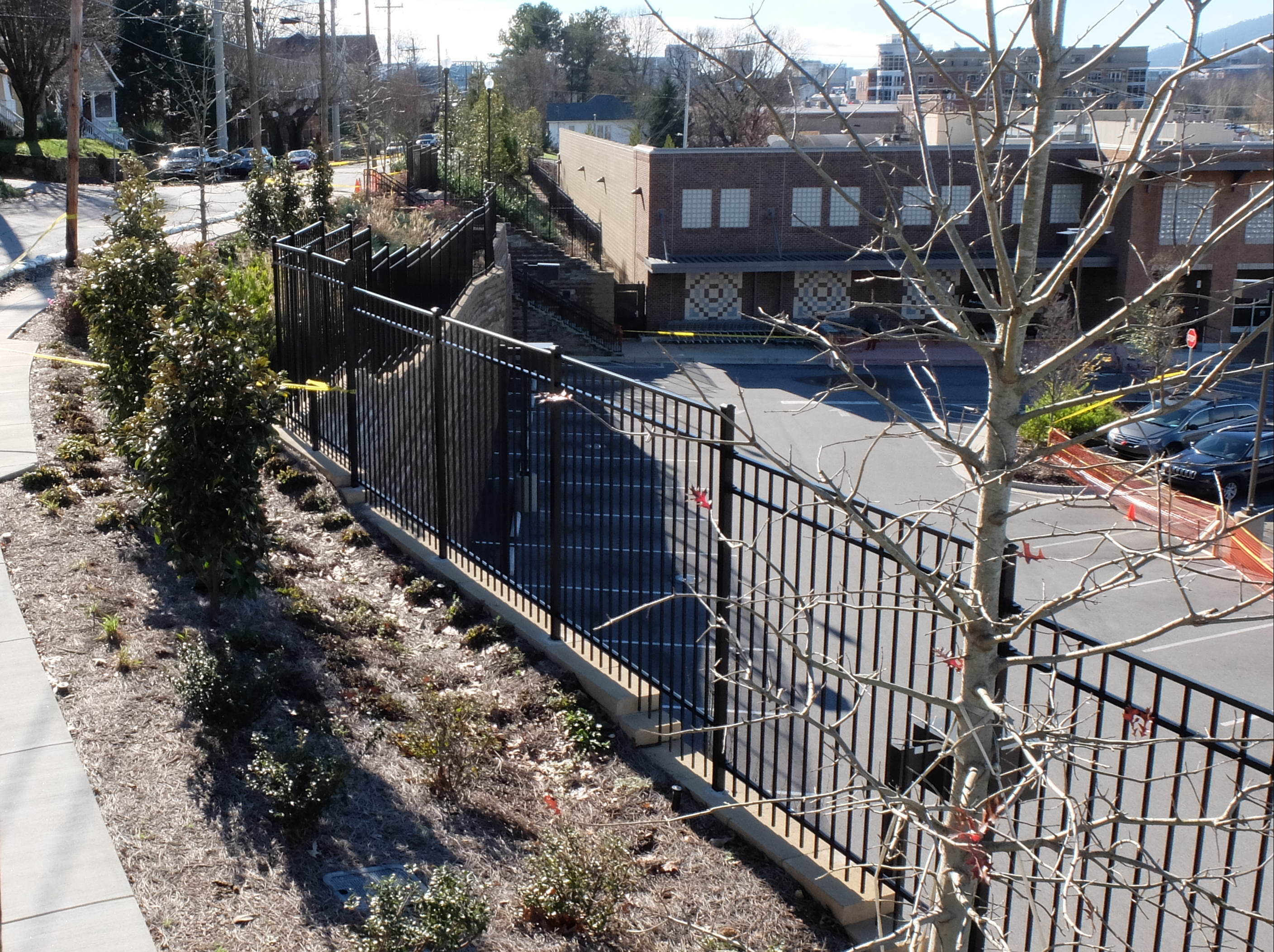 The retaining wall on the east side of the Publix parking lot is suspected of moving as a result of recent heavy rains. Yellow caution tape blocks the sidewalk and sand bags have been placed in the roadway along Woodland and Hamilton Avenues.