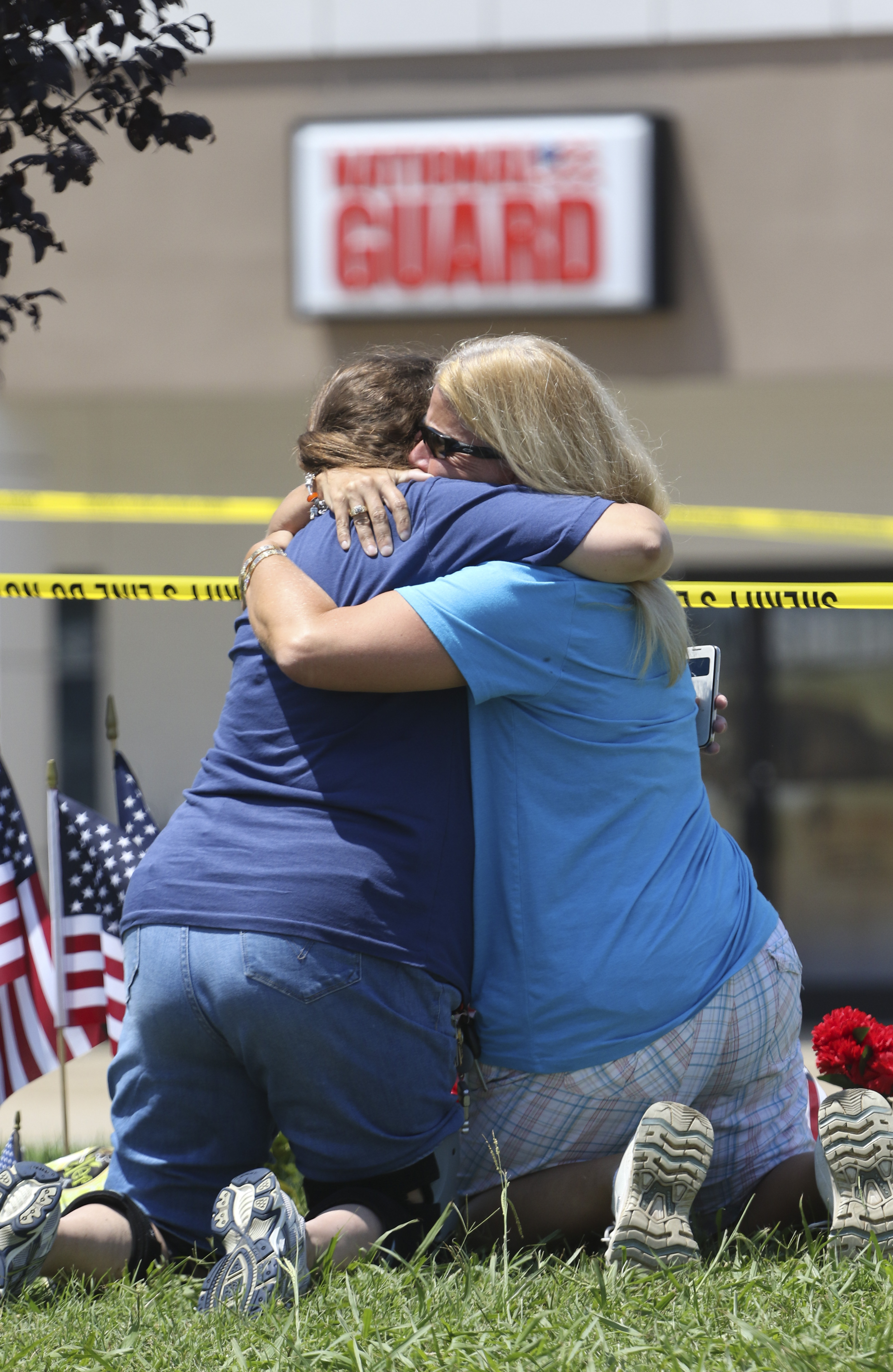 Betty Maynard, left, and Cindy Atterton embrace at a makeshift memorial on July 17 in front of the Armed Forces Career Center off Lee Highway where a shooting spree began that ended in the death of four Marines and one Navy sailor in Chattanooga.