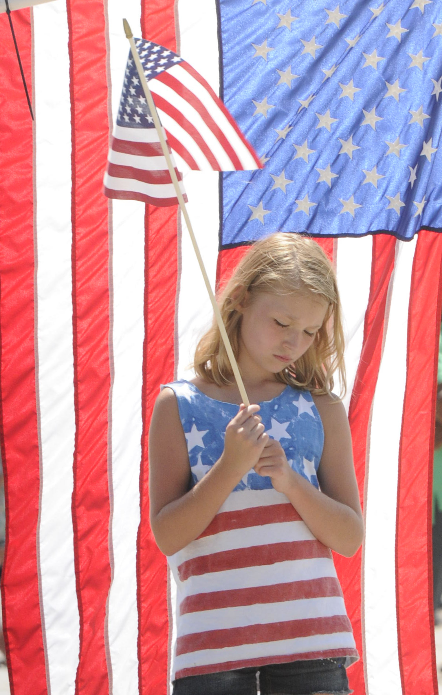 Brooke Lee, 8, bows her head as a funeral procession honoring U.S. Marine Staff Sgt. David Wyatt passes by.