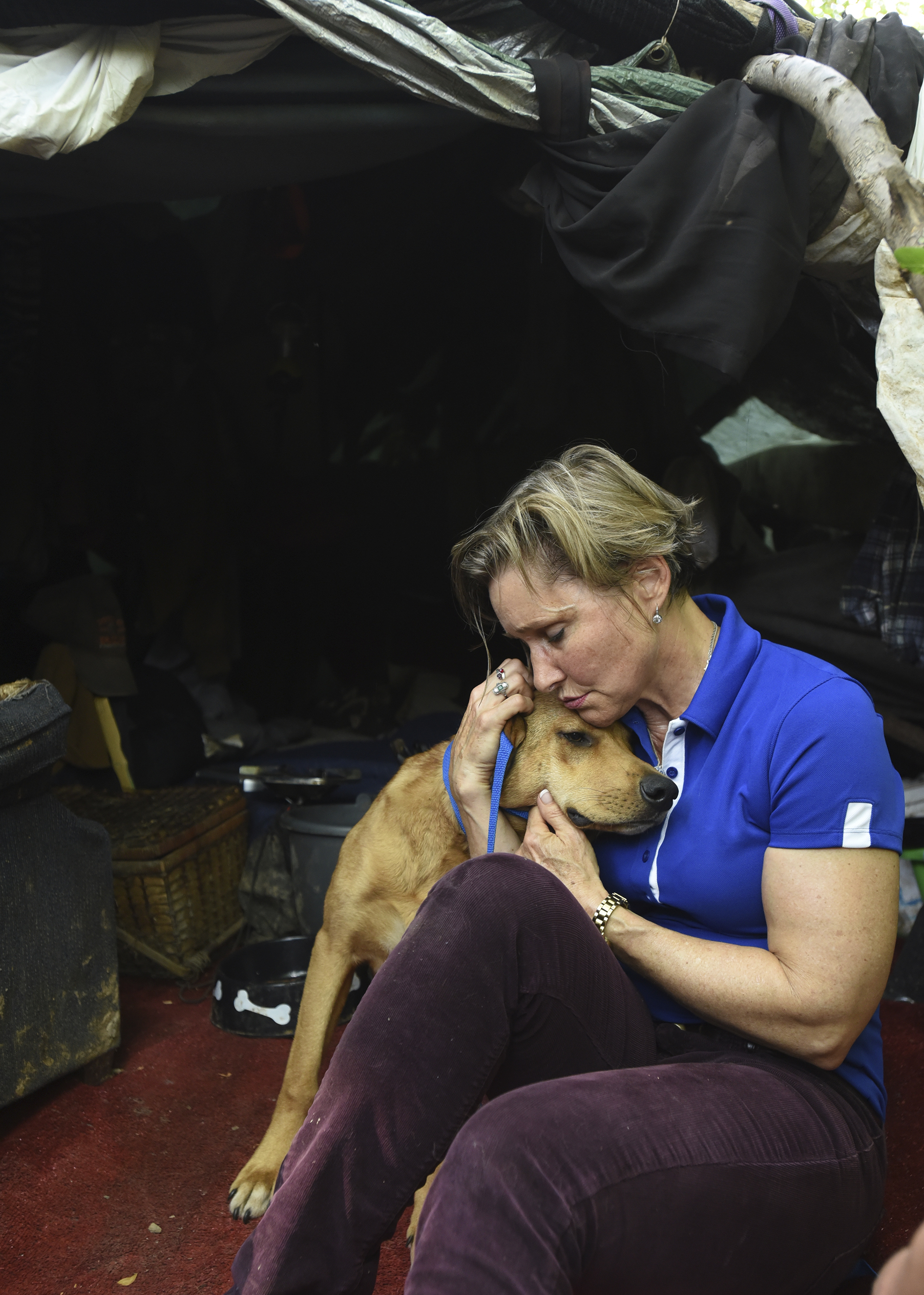 Veterinarian Angelika Lingl snuggles Golden at his homeless owner's campsite in Brainerd on May 8.