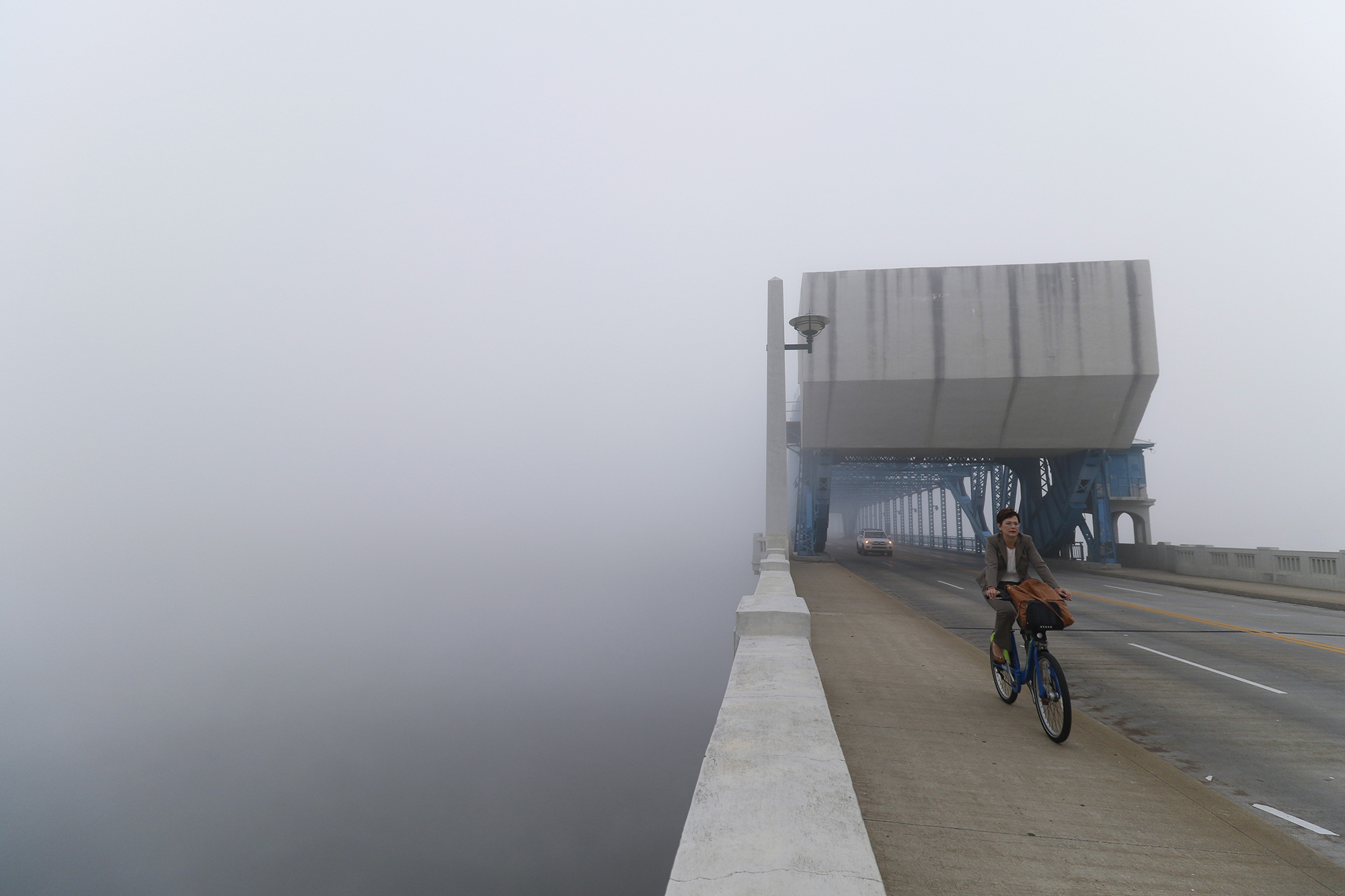 A cyclist travels south through thick fog over the Market Street Bridge on Oct. 12.