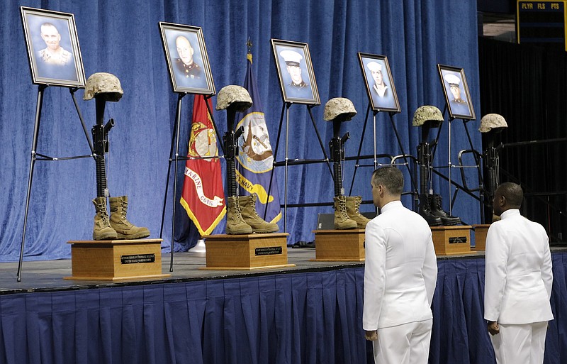 FILE - In this Saturday, Aug. 15, 2015 file photo, U.S. Navy officers pay their respects at the battlefield crosses for the fallen servicemen at a memorial for the five military servicemen killed in the July 16 attacks on two military facilities in Chattanooga. (Doug Strickland/Chattanooga Times Free Press via AP, File)