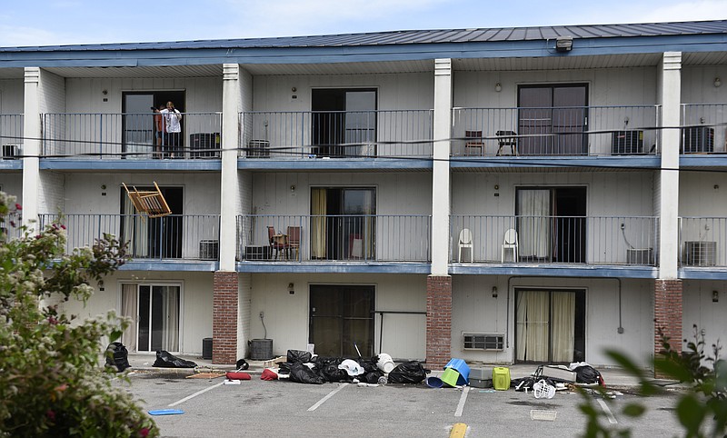 A worker tosses furniture over the third-floor balcony at Superior Creek Lodge in East Ridge, where some 1,500 people were displaced, in September.