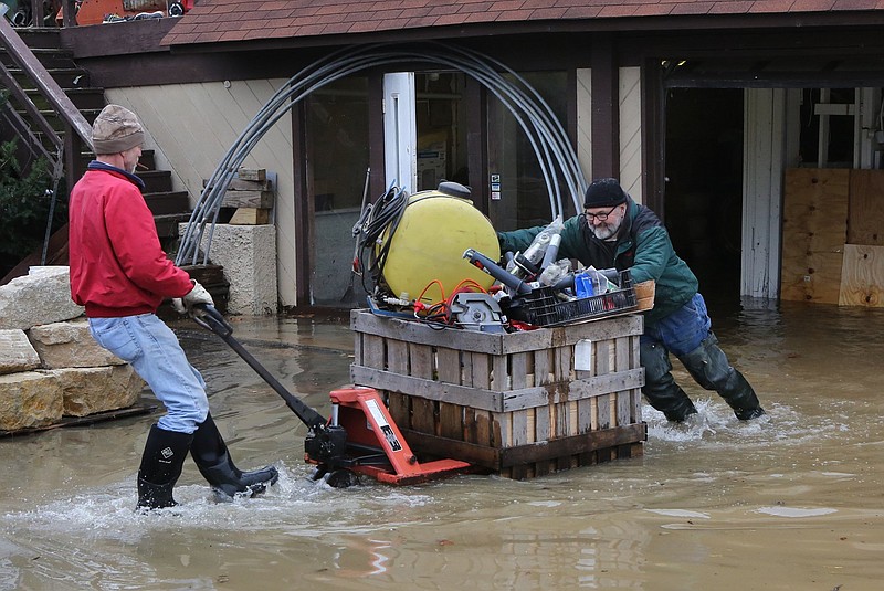 
              Mark Diehl, left, and Dale Atchley move items to higher ground at the Fenton Feed Mill on Tuesday, Dec. 29, 2015, in Fenton, Mo. Torrential rains over the past several days pushed already swollen rivers and streams to virtually unheard-of heights in parts of Missouri and Illinois. (J.B. Forbes /St. Louis Post-Dispatch via AP)  EDWARDSVILLE INTELLIGENCER OUT; THE ALTON TELEGRAPH OUT; MANDATORY CREDIT
            