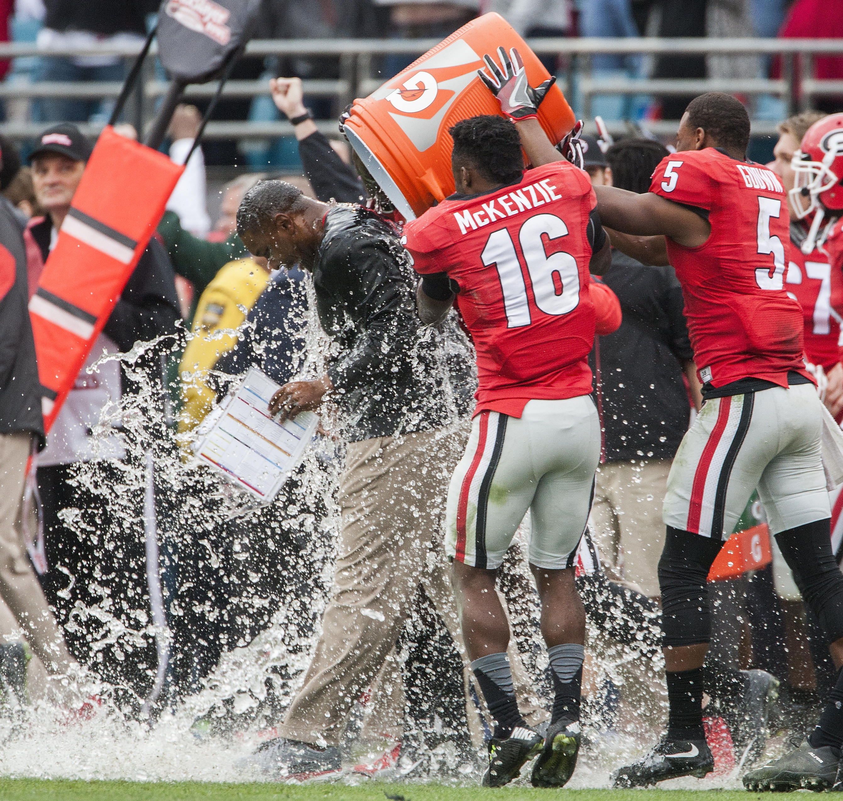 Georgia's Isaiah McKenzie (16) and Terry Godwin (5) dunk interim head coach Bryan McClendon after defeating Penn State 24-17 in the TaxSlayer Bowl NCAA college football game in Jacksonville, Fla., Saturday, Jan. 2, 2016. (AP Photo/Dave Ferrell)